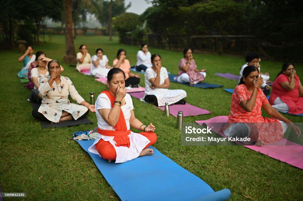 Senior woman doing breathing exercises in a park